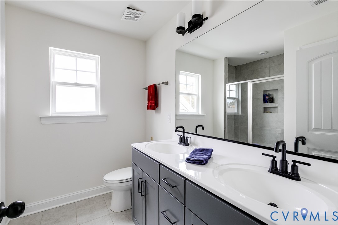 10123 Peach Blossom Road Mechanicsville, VA 23116 - Photo 38 of 49 a bathroom with a toilet sink and mirror