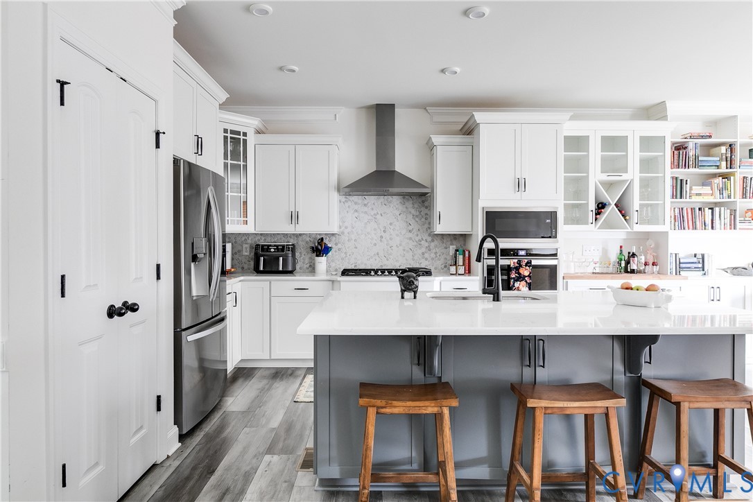 10123 Peach Blossom Road Mechanicsville, VA 23116 - Photo 10 of 49 a kitchen with stainless steel appliances a sink stove refrigerator and cabinets
