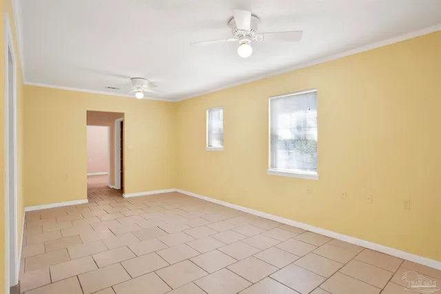 a view of an empty room with window and cabinet area