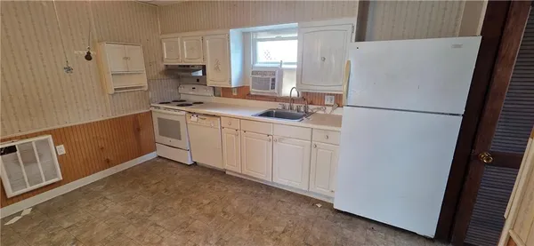 a kitchen with white cabinets and white appliances