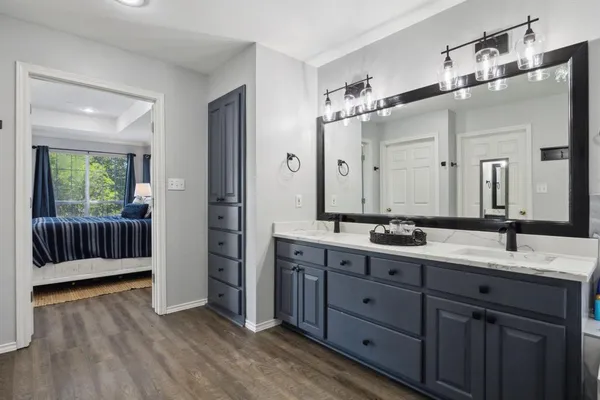 a spacious bathroom with a double vanity sink a large mirror and shower