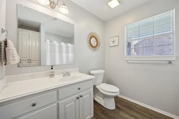a bathroom with a toilet a sink and a mirror
