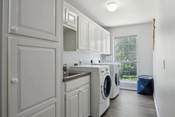 a utility room with sink dryer and washer