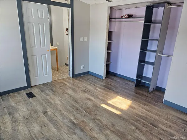 an empty room with wooden floor and a window