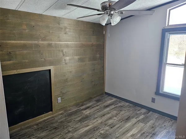 a view of empty room with window and ceiling fan