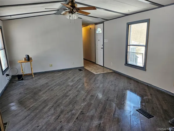 a view of a room with wooden floor and windows
