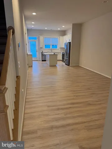 a view of kitchen with refrigerator cabinets and wooden floor