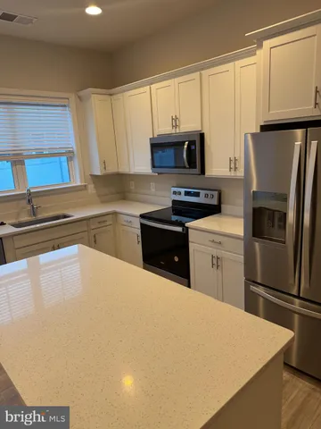 a kitchen with stainless steel appliances a refrigerator stove microwave and sink