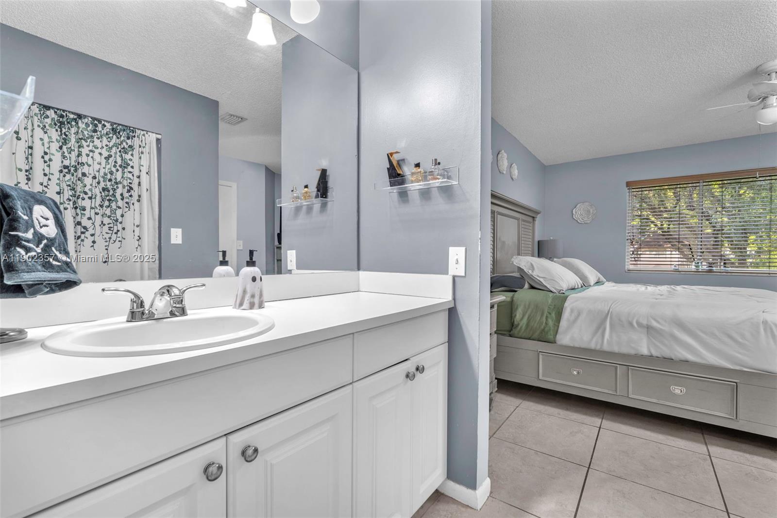 9507 Southwest 140th Court, Unit 9507 Miami, FL 33186 - Photo 16 of 19 a en suite bathroom with a double vanity sink and a mirror