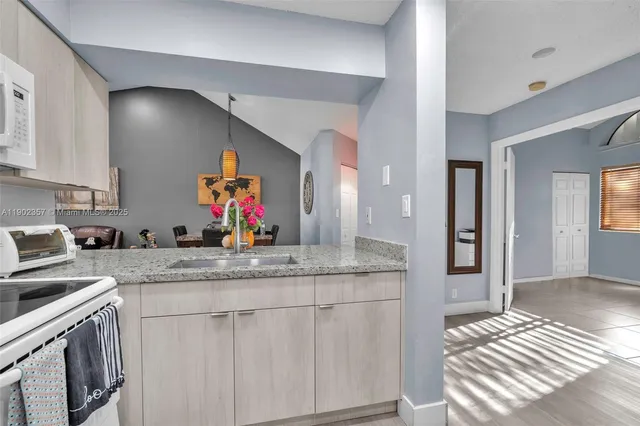 a kitchen with stainless steel appliances granite countertop a sink stove and cabinets