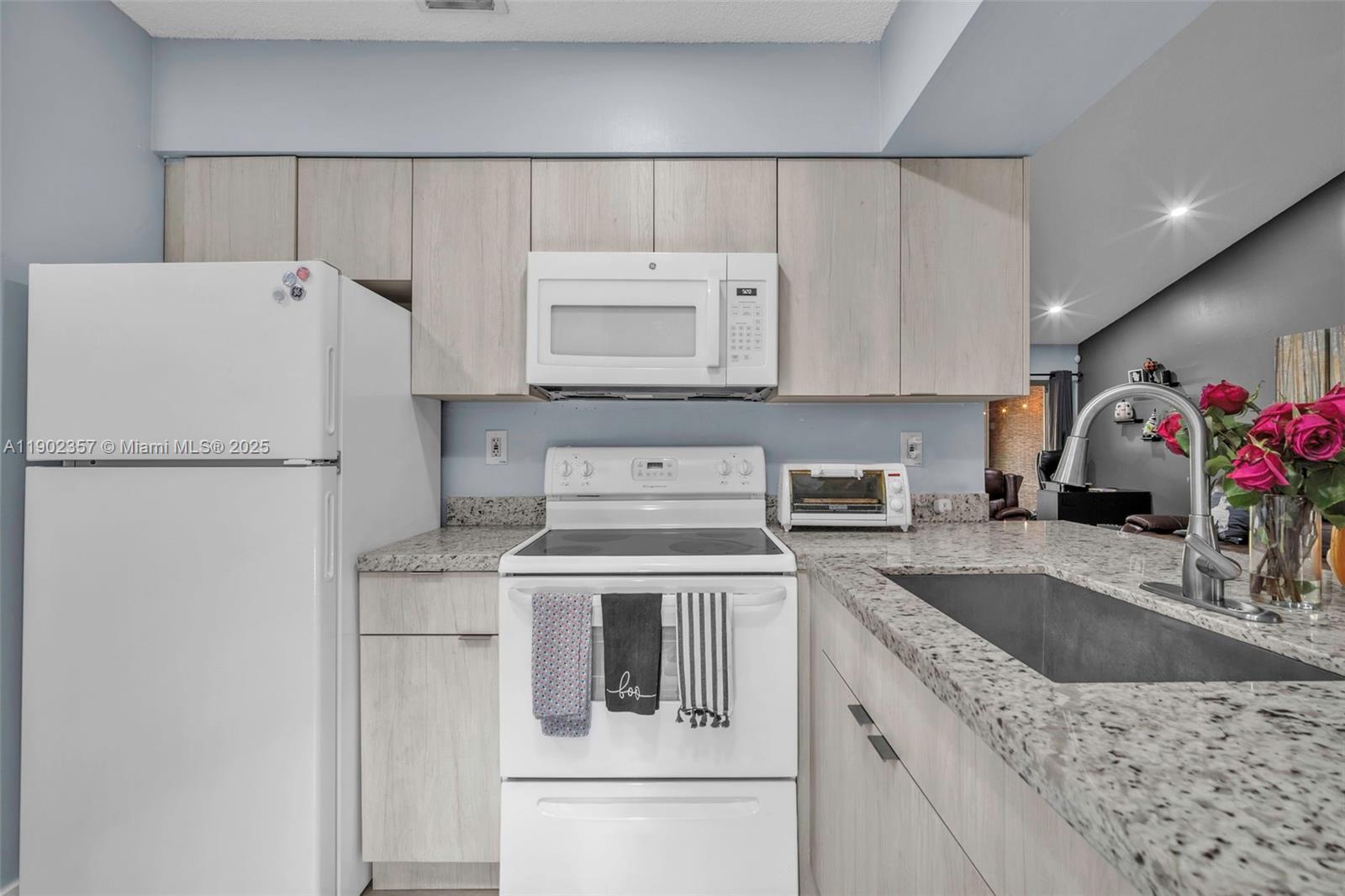 9507 Southwest 140th Court, Unit 9507 Miami, FL 33186 - Photo 10 of 19 a kitchen with a sink a stove and refrigerator