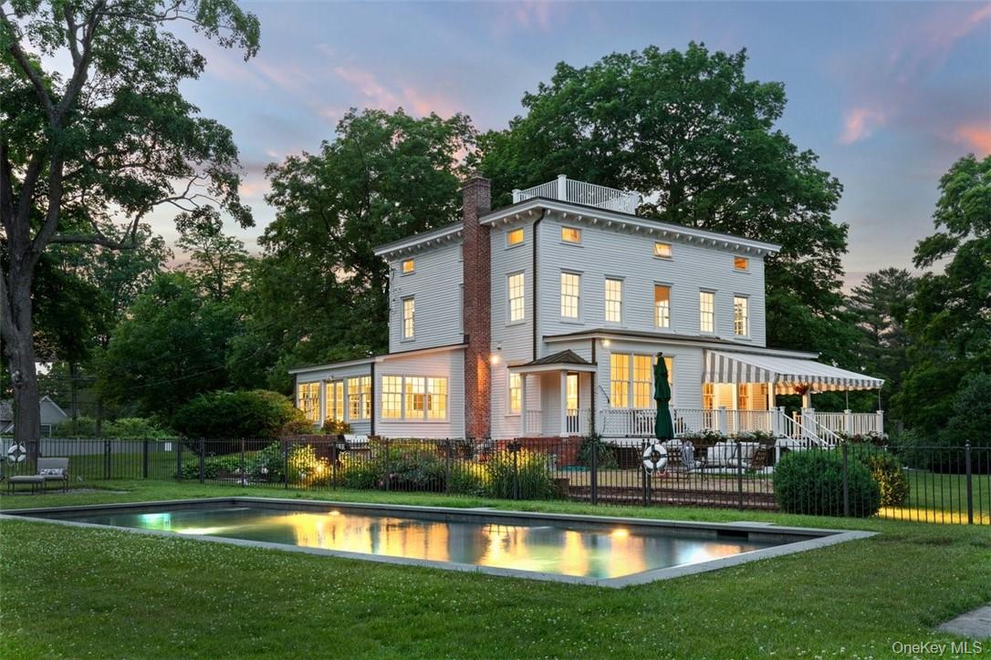 77 Pleasant Ridge Road Harrison, NY 10528 - Photo 2 of 35 a front view of a house with swimming pool and garden