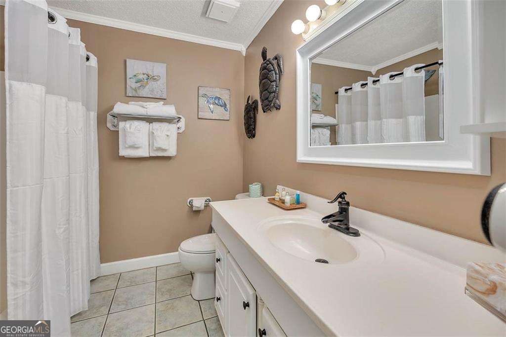 1175 North Beachview Drive, Unit 234 Jekyll Island, GA 31527 - Photo 3 of 17 a bathroom with a sink a toilet and mirror
