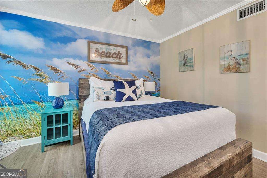 1175 North Beachview Drive, Unit 234 Jekyll Island, GA 31527 - Photo 5 of 17 a bedroom with a bed and a wooden floor