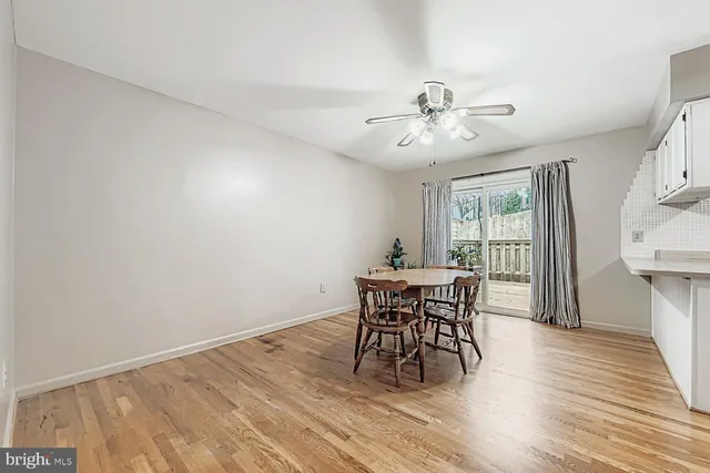 a dining room with furniture a chandelier and wooden floor