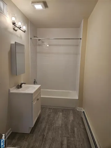 a bathroom with a tub sink and mirror