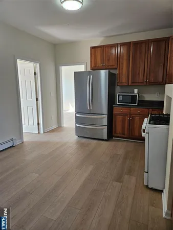 a kitchen with granite countertop wooden cabinets and refrigerator