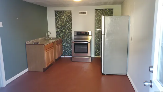 a view of a kitchen with furniture and a refrigerator