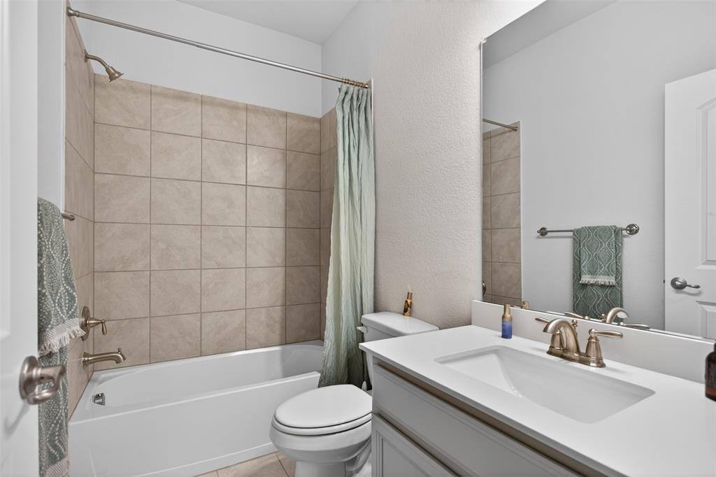 1002 Coppersmith Way Forney, TX 75126 - Photo 13 of 39 a bathroom with a sink a toilet and shower