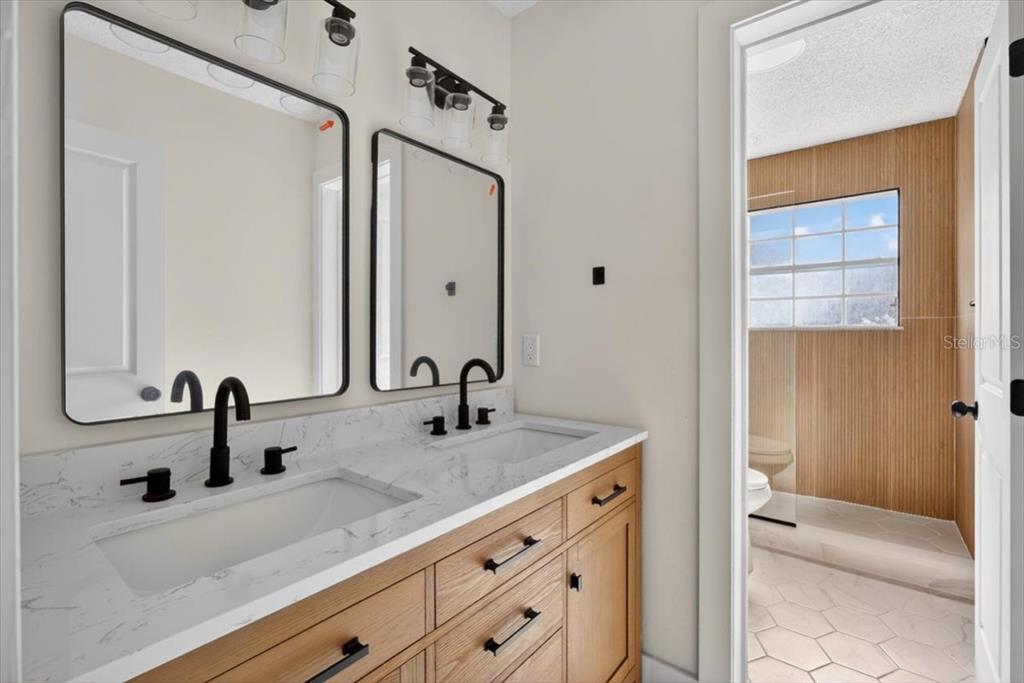 8618 Valley Ridge Court Orlando, FL 32818 - Photo 17 of 24 a bathroom with a sink and a mirror