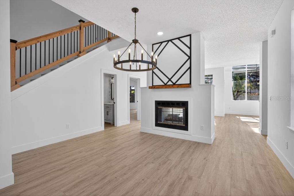 8618 Valley Ridge Court Orlando, FL 32818 - Photo 3 of 24 a view of an empty room with wooden floor fire place