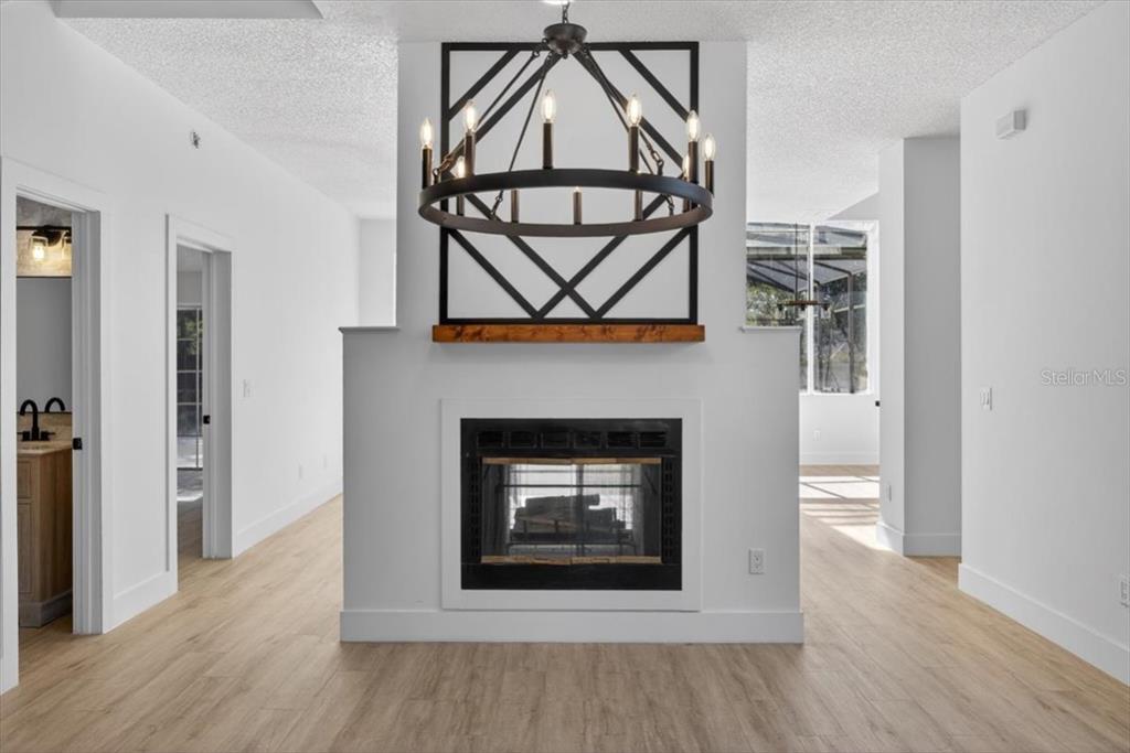 8618 Valley Ridge Court Orlando, FL 32818 - Photo 4 of 24 an empty room with wooden floor a fireplace and cabinet