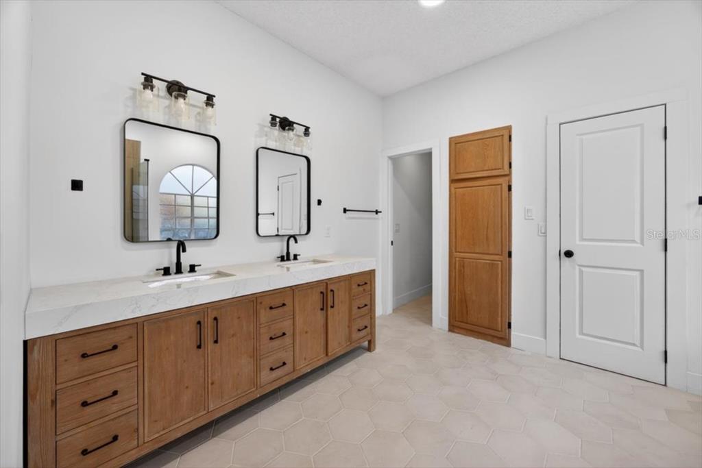 8618 Valley Ridge Court Orlando, FL 32818 - Photo 7 of 24 a bathroom with a double vanity sink and a mirror