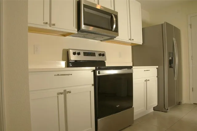 a kitchen with stainless steel appliances white cabinets and a refrigerator