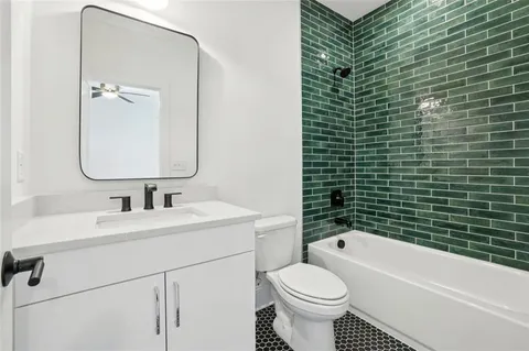 a bathroom with a double vanity sink toilet mirror and shower