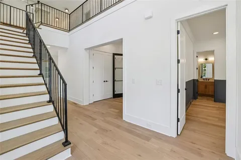 a view of a hallway with wooden floor and staircase