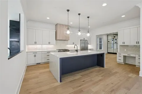 a large kitchen with kitchen island a sink stainless steel appliances and cabinets