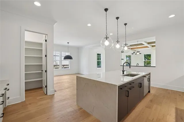 a view of a kitchen island a chandelier and wooden floor
