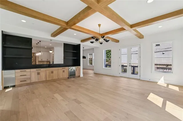 a view of a livingroom with kitchen and natural light
