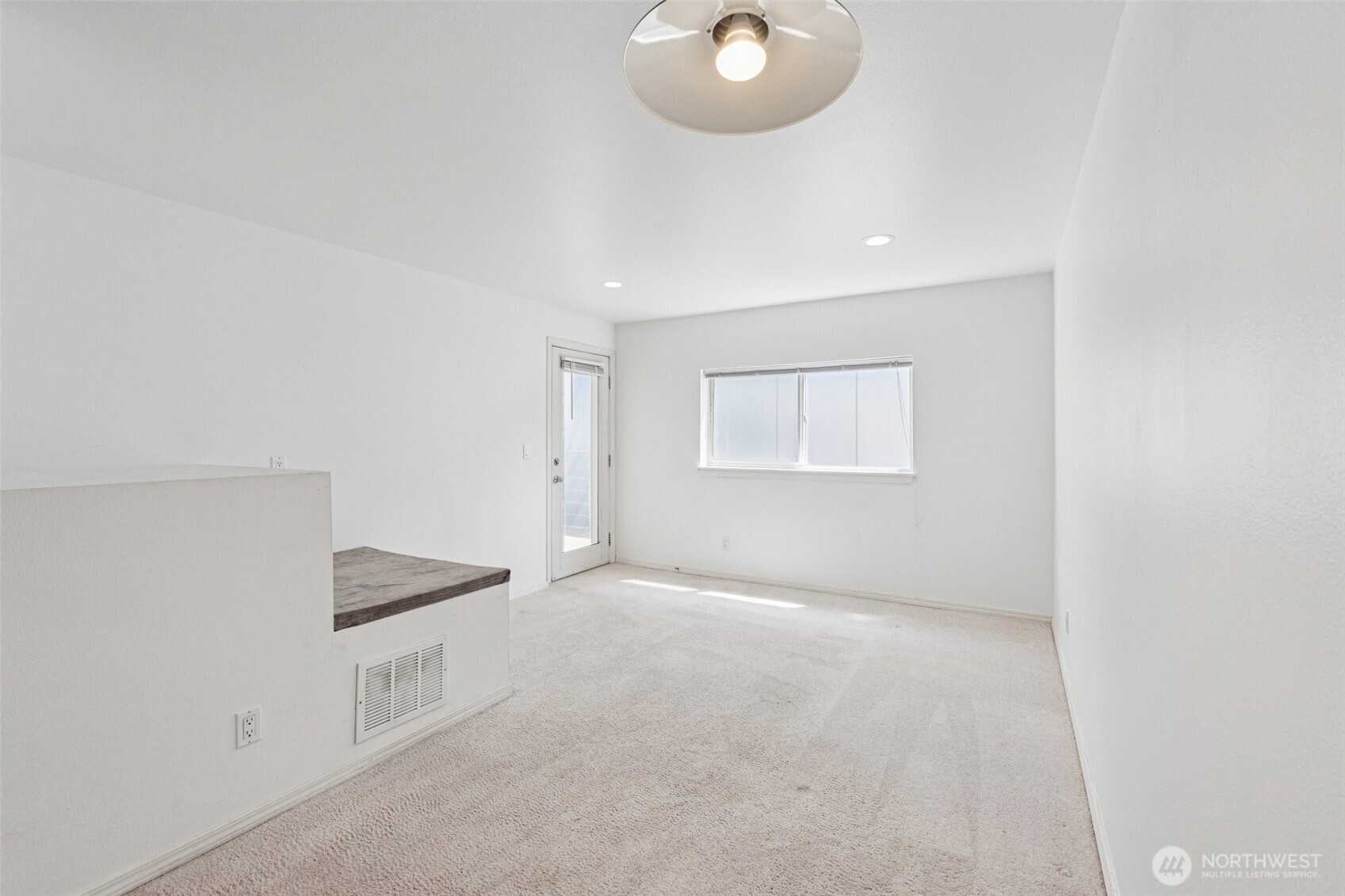 5624 Roosevelt Way Northeast, Unit 202 Seattle, WA 98105 - Photo 3 of 21 an empty room with a chandelier fan and windows
