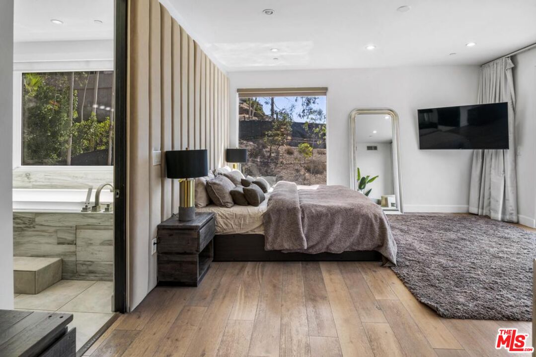 6696 Lakeridge Road Los Angeles, CA 90068 - Photo 11 of 19 a bedroom with a bed and large window