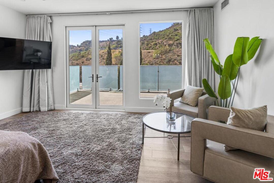 6696 Lakeridge Road Los Angeles, CA 90068 - Photo 15 of 19 a living room with furniture a flat screen tv and a floor to ceiling window