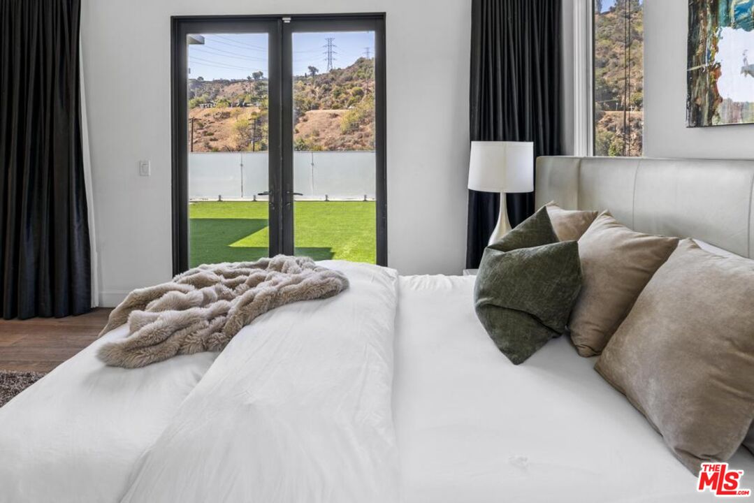 6696 Lakeridge Road Los Angeles, CA 90068 - Photo 18 of 19 a large bed sitting in a bedroom next to a window