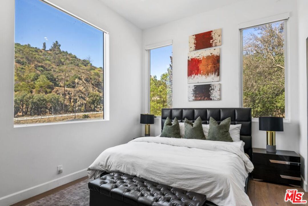 6696 Lakeridge Road Los Angeles, CA 90068 - Photo 7 of 19 a bedroom with a bed and a painting on the wall