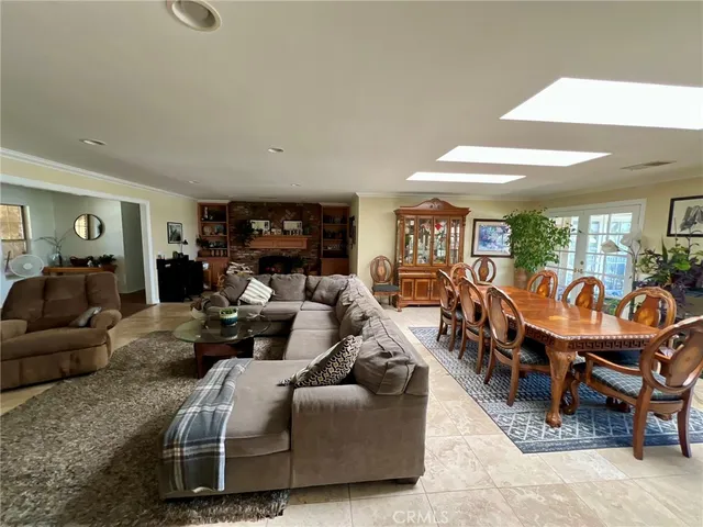 a living room with furniture kitchen view and a large window
