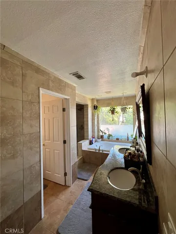 a bathroom with a tub a sink and a large mirror