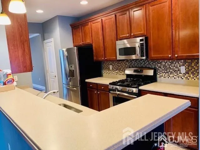 a kitchen with stainless steel appliances a stove microwave and refrigerator