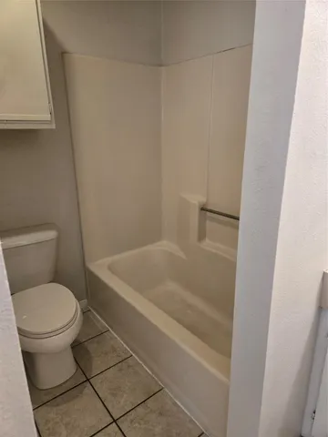 a white toilet sitting next to a bath tub