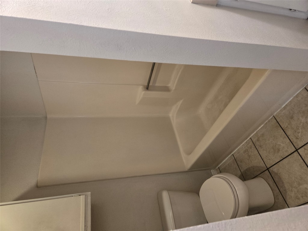 2903 West Slaughter Lane, Unit B Austin, TX 78748 - Photo 15 of 20 a white toilet sitting next to a bath tub