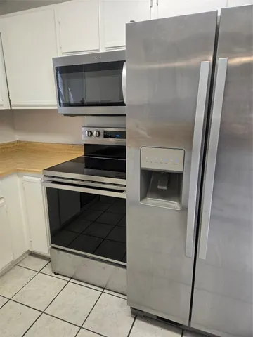 a kitchen with granite countertop cabinets and steel stainless steel appliances