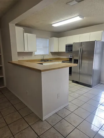 a kitchen with stainless steel appliances granite countertop a refrigerator sink and cabinets