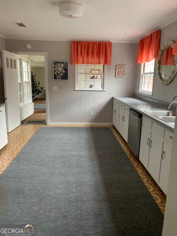 a view of kitchen with windows and refrigerator