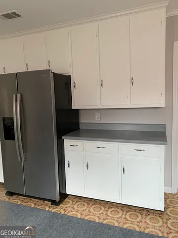 a view of cabinets and refrigerator