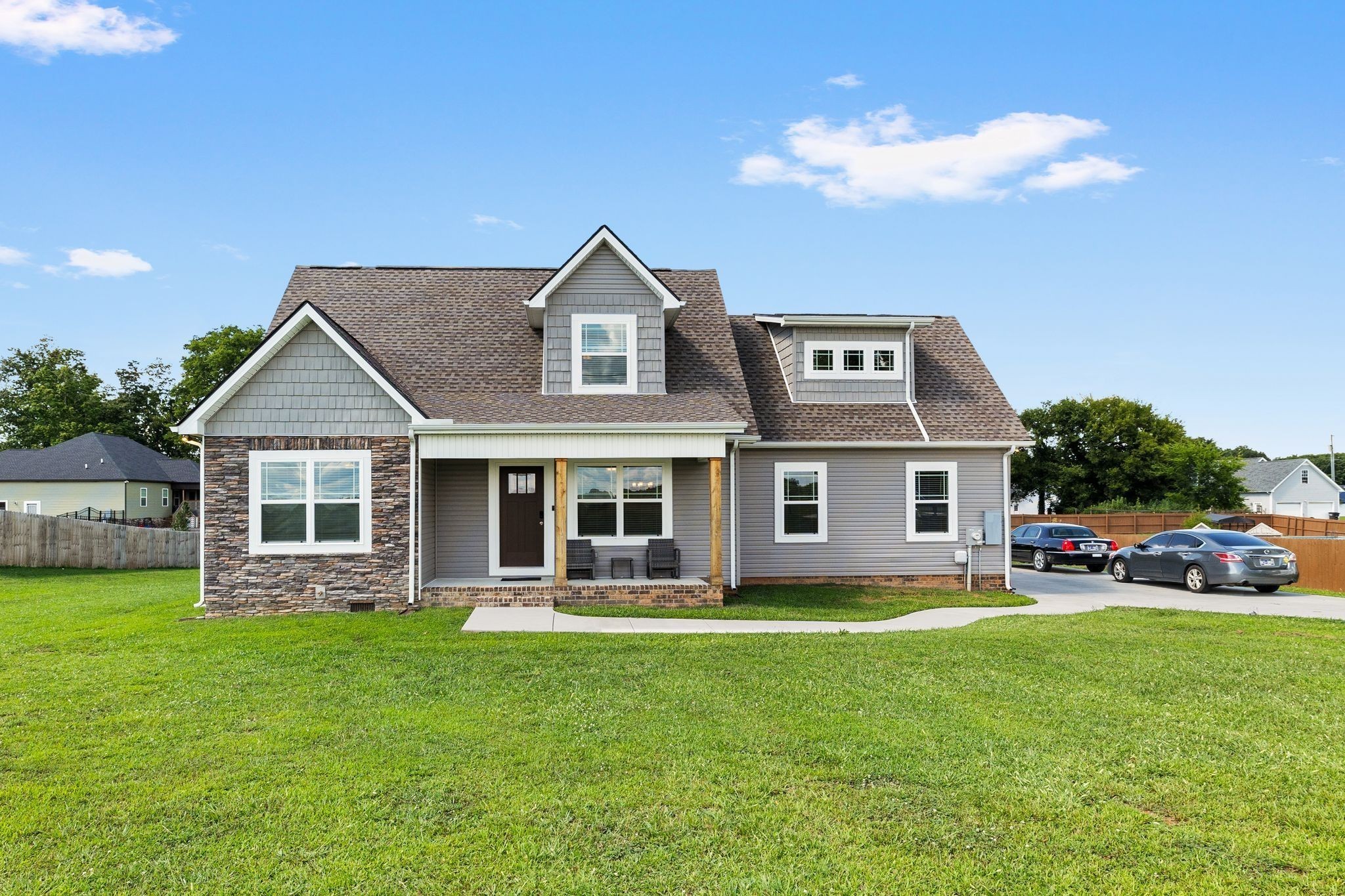 a front view of a house with a garden and trees