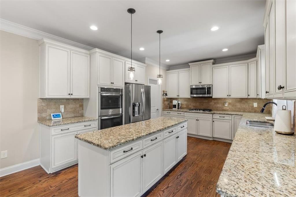 802 Double Branches Lane Dallas, GA 30132 - Photo 19 of 80 a large kitchen with granite countertop a stove a sink dishwasher a refrigerator and white cabinets with wooden floor