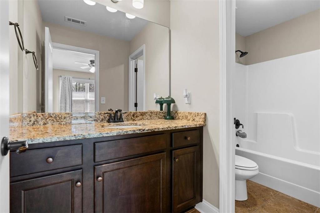 802 Double Branches Lane Dallas, GA 30132 - Photo 37 of 80 a bathroom with a granite countertop sink toilet a large mirror a bathtub and shower